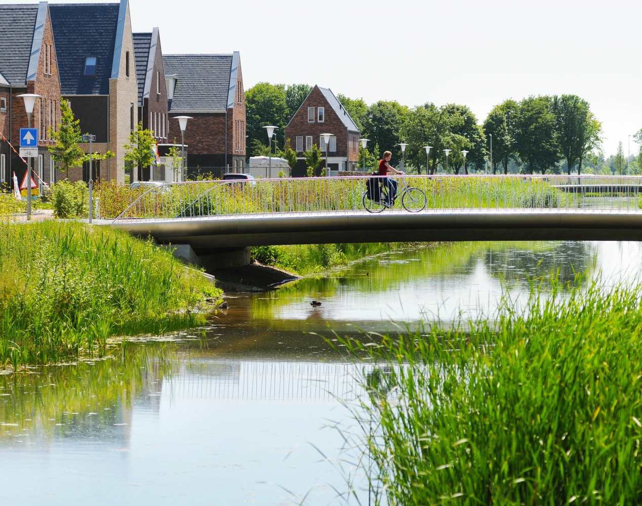 Schuytgraaf buurtje uitkijkend over water en fietser over brug